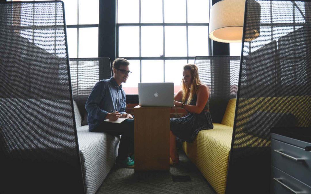 Due colleghi ad un tavolo che discutono di lavoro